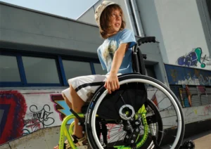young boy sitting in a ki mobility wheelchair
